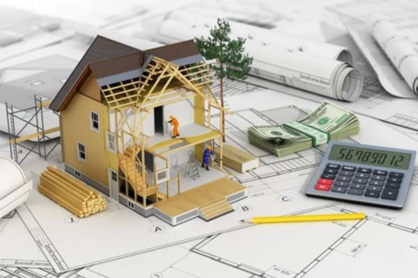 A miniature house on blueprints, surrounded by a worker, planks, dollar bills, and a calculator, symbolizes construction and budgeting.
